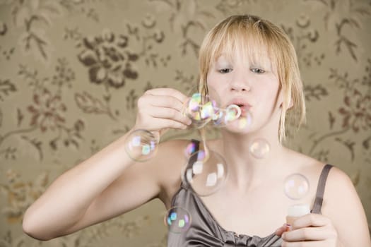 Pretty young girl with blue eyes blowing bubbles