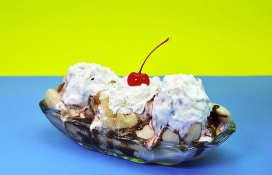 Banana split isolated on blue and yellow background.