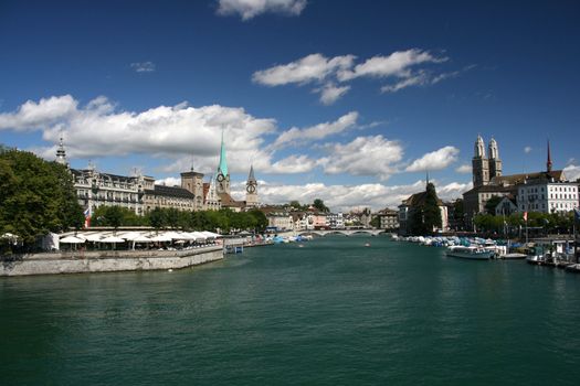 Zurich cityscape seen from Quaibruecke (Quai Bridge). Grossmuenster (The Cathedral) on the right side. Limmat River.