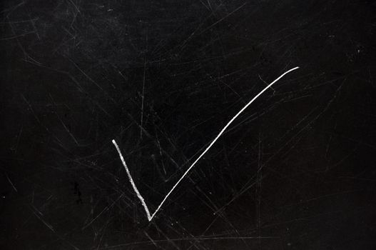 Checkmark on black chalkboard with copy space.