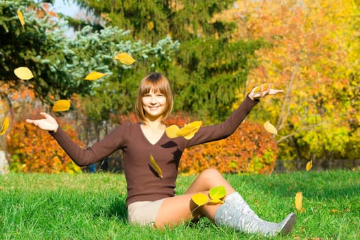 The young girl in autumn park during a leaf fall