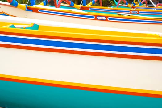 Close up of colourful fishing boats on shore.