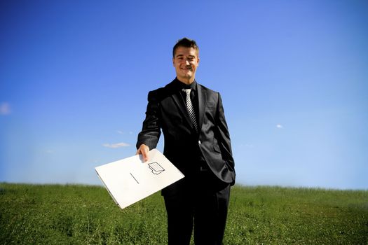 Business man in the middle of the field handing a folder