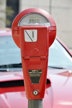 Red parking meter on downtown street. 