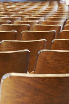 rows of wood chairs in an old auditorium