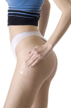 young woman scrubbing her legs with a beauty product