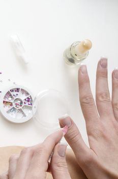 young woman painting her finger nails in a sort of nail art