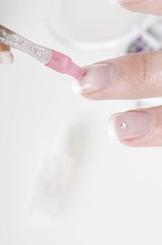 young woman painting her finger nails in a sort of nail art