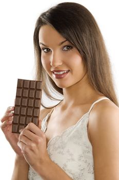 brunette in white dress showing a block of chocolate smiling