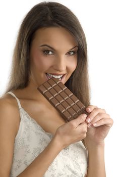 pretty young brunette biting a block of chocolate with her teeth