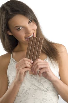 brunette eating a block of chocolate wearing a white dress