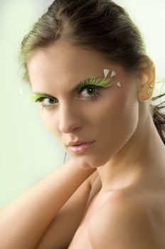 portrait of a young and cute woman with artificial green eyelashes and green eyes