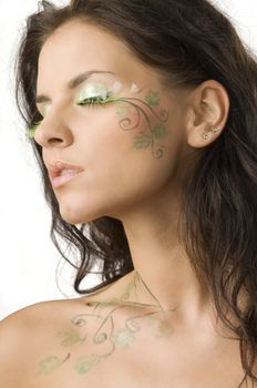 beautiful girl with body paint on her face and shoulder keeping her eyes closed