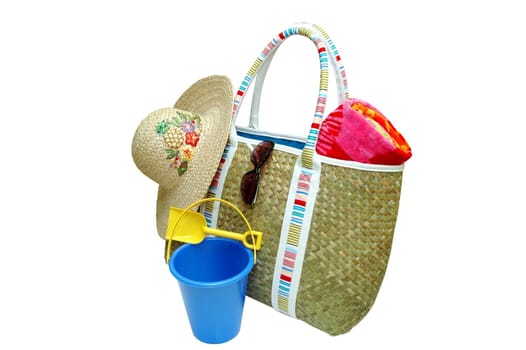 Beach bag with beach towel, sunglasses, sun hat, and sand pail with shovel.  Isolated with clipping path.
