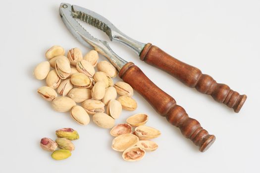 pistachio nuts with nut cracker isolated in white background
