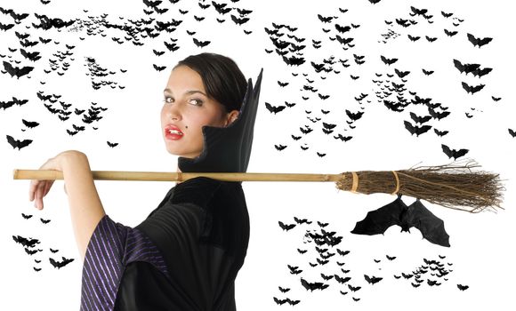pretty witch in black dress with her broom on shoulder and black bat flying