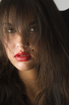 close up of brunette with red lips and long hair looking in camera