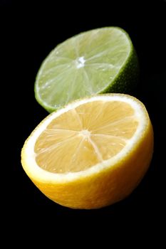 Lemon and lime halves isolated on black background.