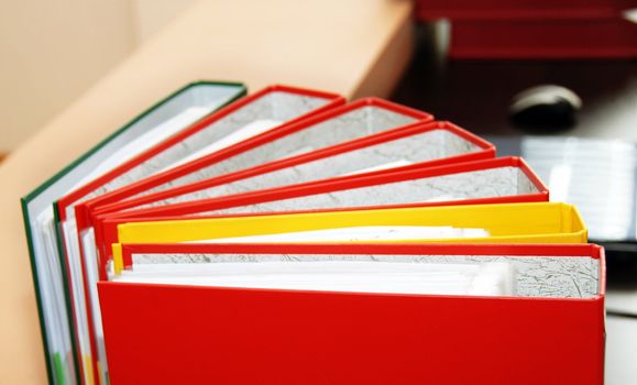 colorful files with documents  on office desk