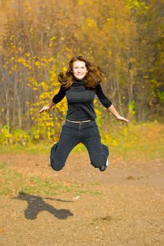 The jumping girl against the autumn nature