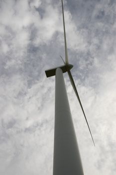 a wind turbine against a calm cloudy sky