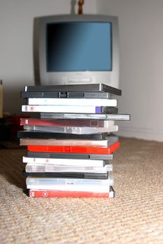 a pile of dvds in front of a tv set