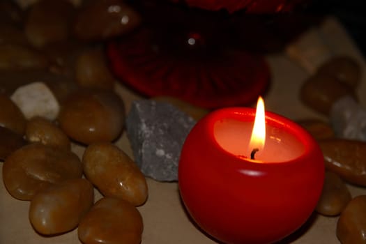 a red candle burning among stones for calm