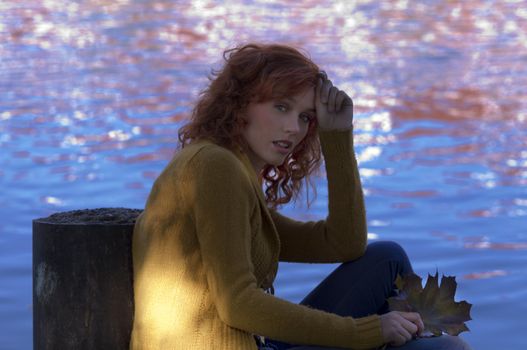 red haired woman with yellow cardigan and blue river water in background