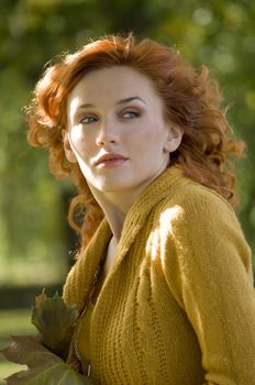 outdoor portrait of a cute young woman with red hair in wind