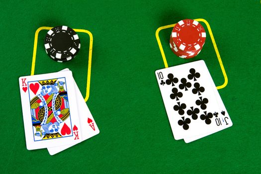 Cards and poker chips on green background - top view.