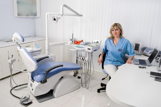 dentist office interior, female doctor sitting at the table