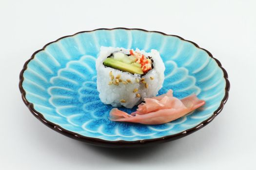 Sushi and ginger root on a blue dish.
