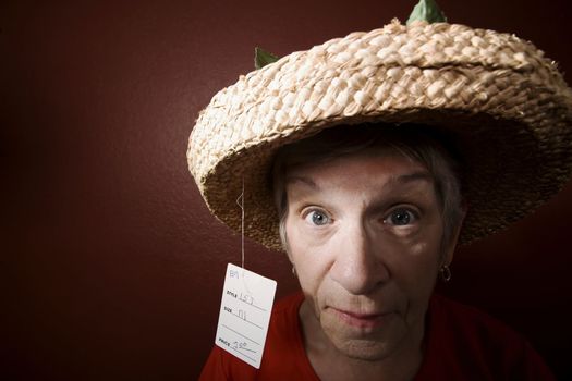 Senior woman in a red shirt and cheap straw hat
