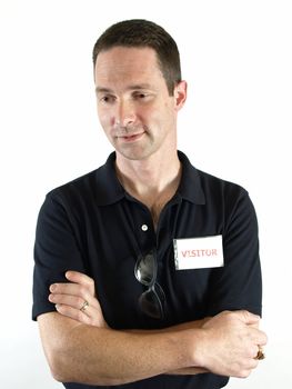 Male with arms crossed, a visitor badge and a pair of safety glasses hanging on his shirt.