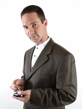 A man in a suit holds a pda in his hand, ready to make a note.