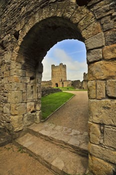 The tower of an ancient castle, viewed through a stone arch.