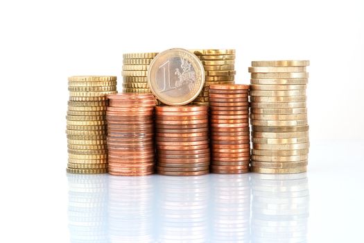 euro coins piled up with one euro, fifty, twenty, ten, five, two and one cent coins, isolated on white background