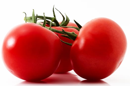 closeup of three red tomatoes on white background