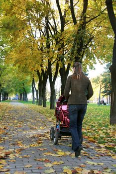 Young mother walks in park with the child