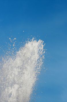 The jet of water aspires in the blue sky