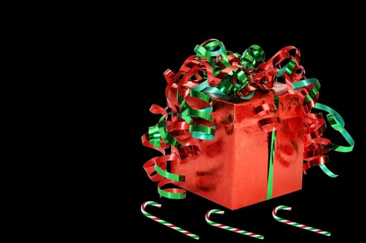 Christmas gift and candy canes isolated on black background.