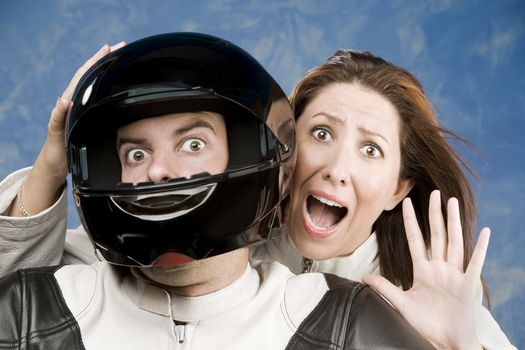 Man and fearful woman on a motorcycle in studio