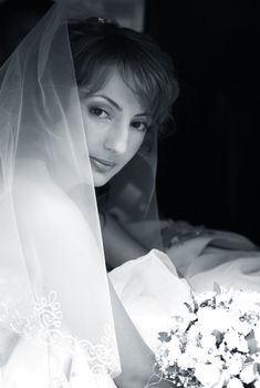 Beautiful the bride with a bouquet in the automobile
