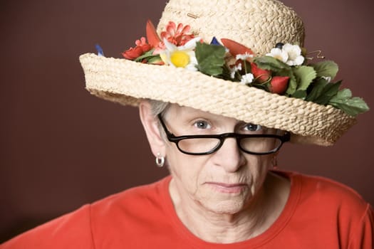 Senior woman in a red shirt and straw hat