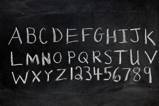 Alphabet and numerals on black chalkboard with copy space.  