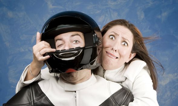 Man and fearful woman on a motorcycle in studio