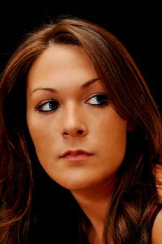 Dramatic brunette female portrait on black background.  