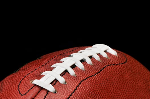 American football closeup isolated on black background.  