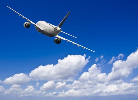 Civil aircraft travelling in deep blue skies with some cloud