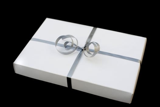 a white box gift wrapped with a silver ribbon on a black background